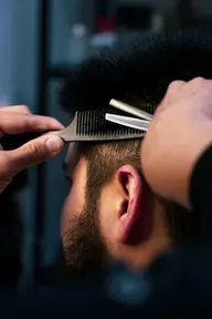 Barber trimming a customer's hair with a comb and scissors